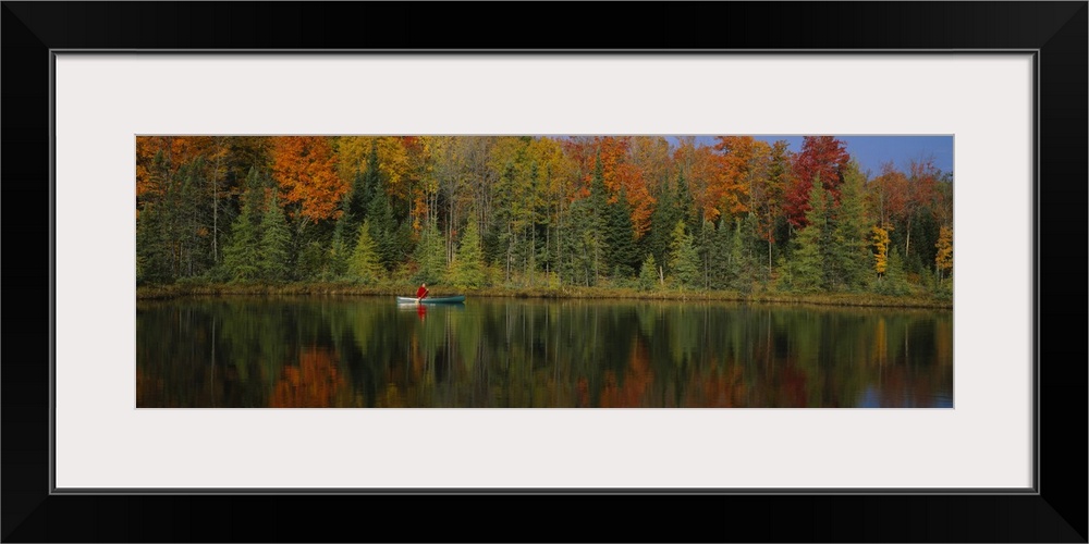 A lone canoer on the lake during the fall in Antigo, Wisconsin.