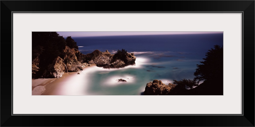 Larges rocks in the water and along the shore  of the Pacific Ocean in Big Sur, California.