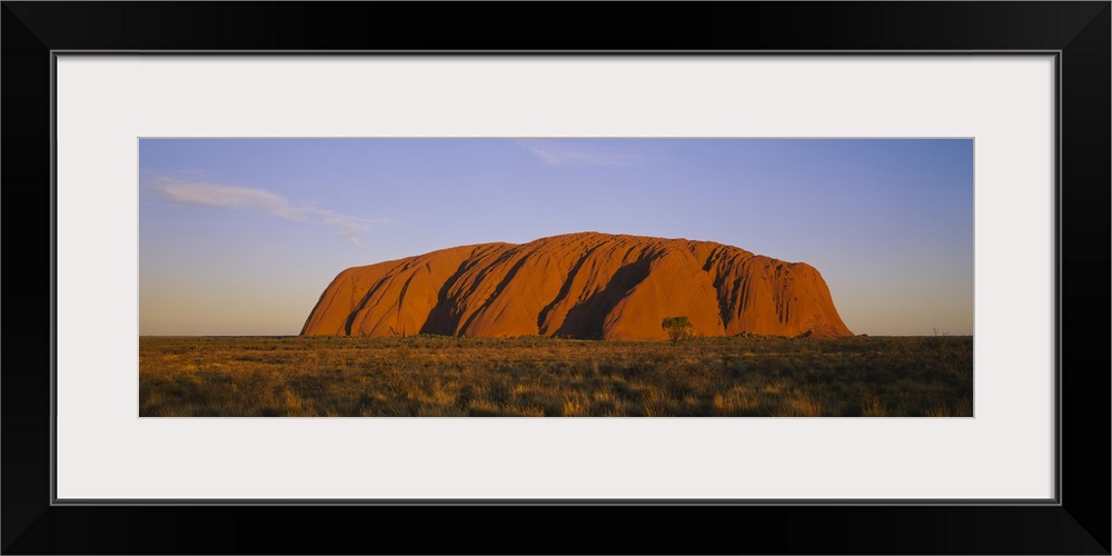 A large sandstone landmark rises out of the desert plains in this panorama photographic wall art.