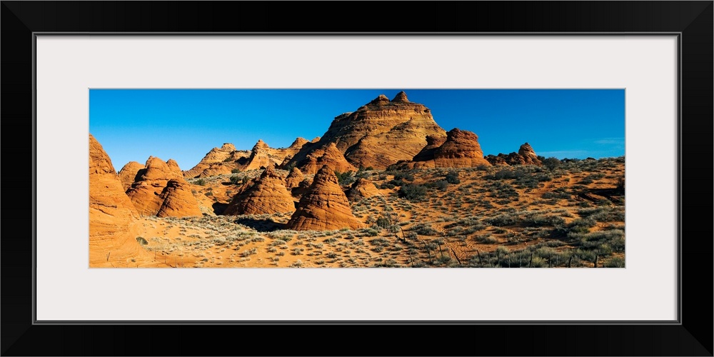 Panoramic photograph shows a field of rock structures among a dry terrain in the Southwestern United States on a cloudless...