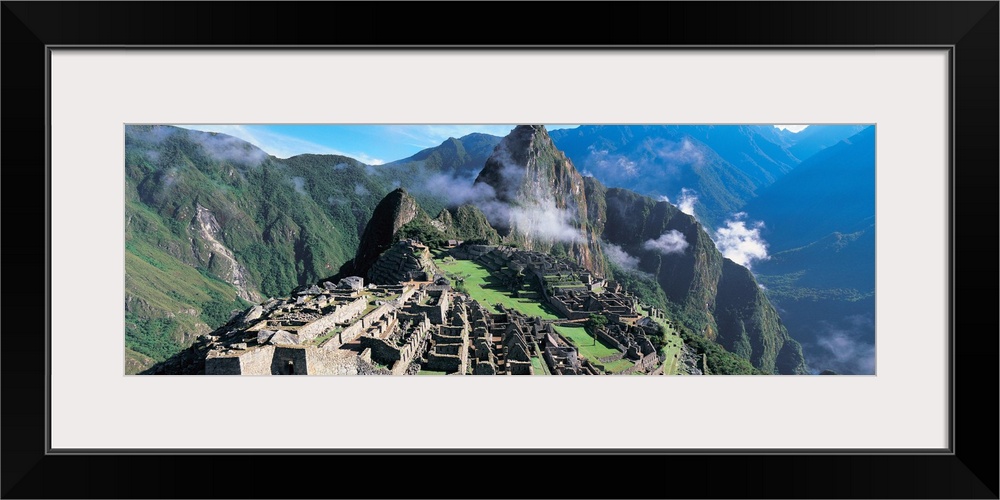Ruins of an ancient civilization lay on a hill under a towering mountain in a valley in South America.