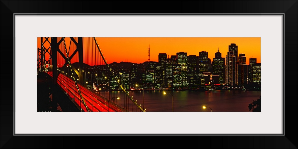 Panoramic photograph shows a large overpass near the coast of the Western United States brightly shining in the dimming li...