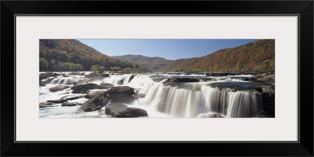 Panoramic image on canvas of long waterfalls with rolling mountains of fall foliage in the background.