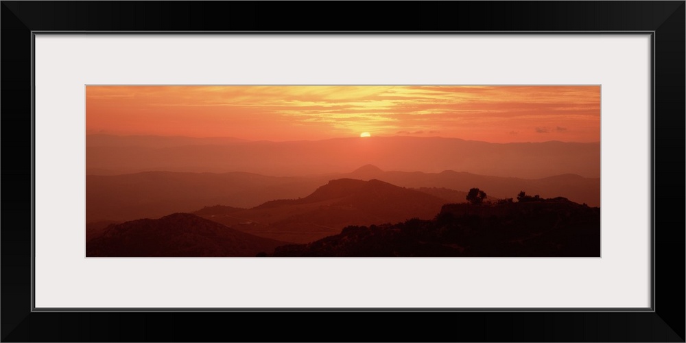 Giant panoramic photo on canvas of layers of Italian hills with a setting sun in the distance.