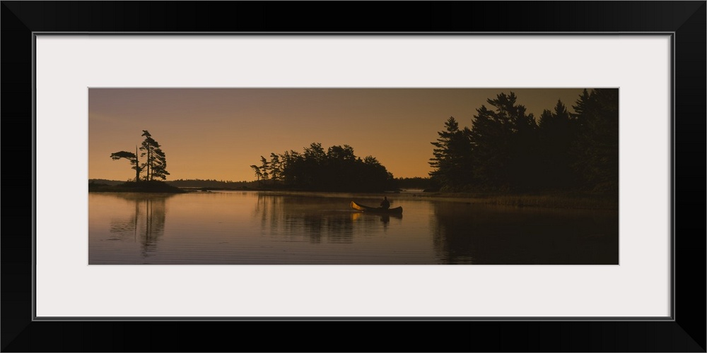 Silhouette of a person in a canoe on a lake, Kejimkujik Lake, Kejimkujik National Park, Nova Scotia, Canada