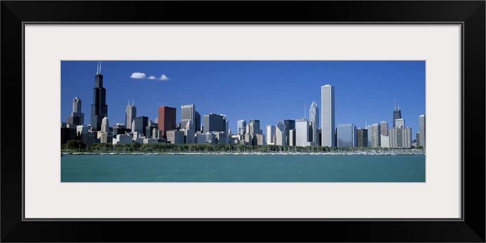 Panoramic photograph shows a row of skyscrapers in the Midwestern United States overlooking the calm waters of a river on ...