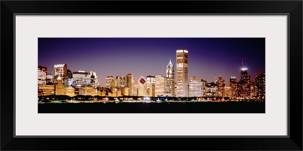 Panoramic photograph shows the intensely vibrant lights of skyscrapers that fill the busy skyline of Chicago, Illinois dur...