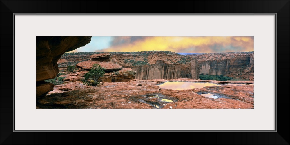 Slickrock waterpocket pools reflect sunrise colors, Canyon De Chelly National Monument, Arizona, USA.