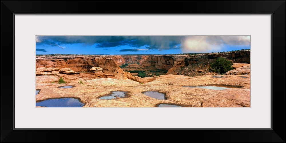 Slickrock waterpocket pools reflect sunrise colors, Canyon De Chelly National Monument, Arizona, USA.