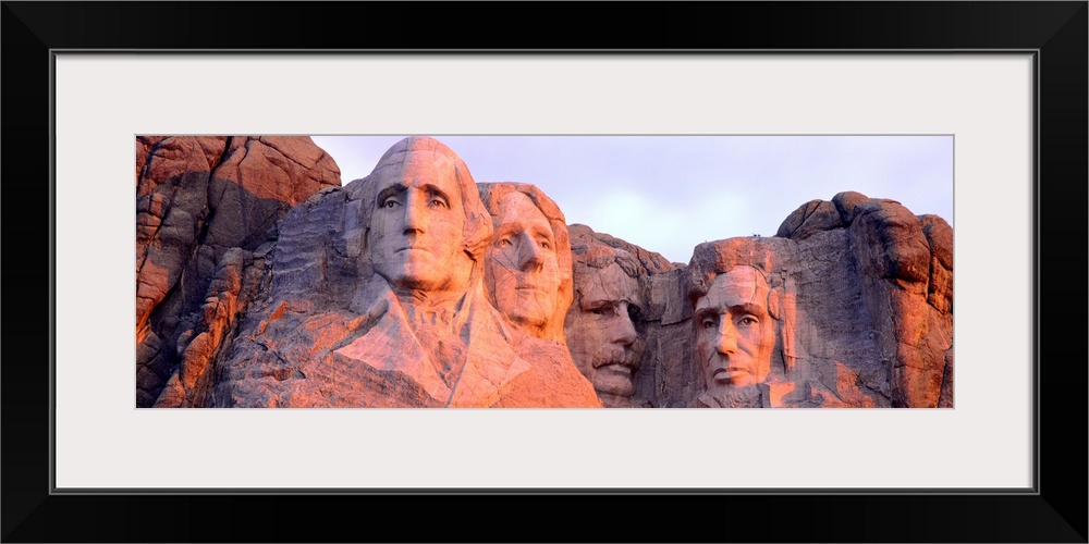 Panorama of the world famous monument, Mount Rushmore, cast in the light of the setting sun.