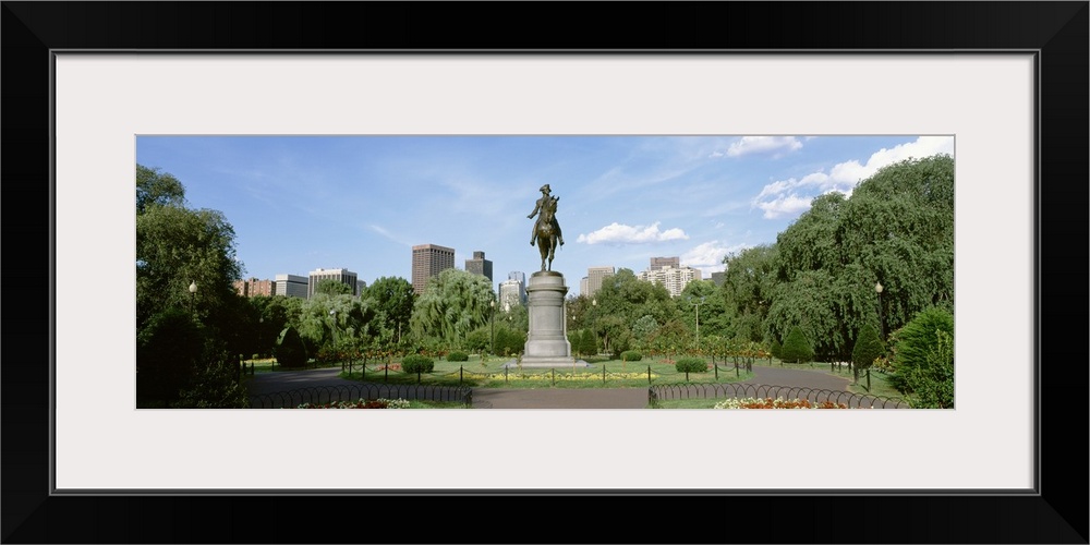 Statue of a man riding a horse in the middle of well kept city park in Boston, Massachusetts.