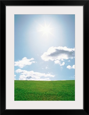 Sun shining with clouds over grassland