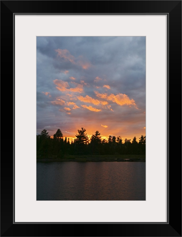 Sunset behind silhouetted forest, Lake Three, Boundary Waters Canoe Area Wilderness, Minnesota