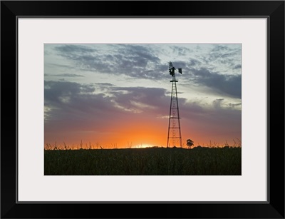 Sunset behind silhouetted windmill, Iowa