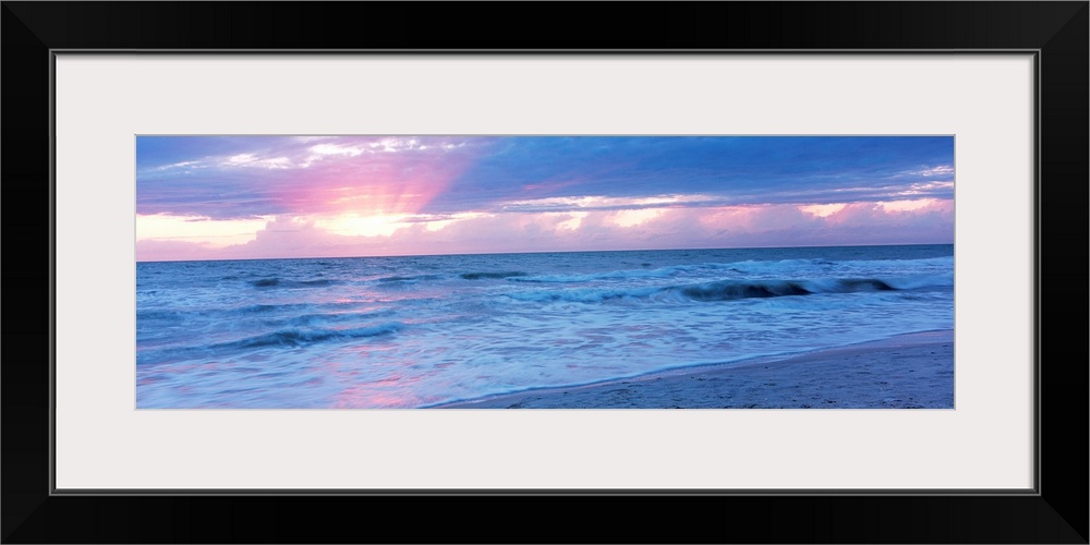 Large panoramic photo of the sun setting over a beach in Naples, Florida (FL).