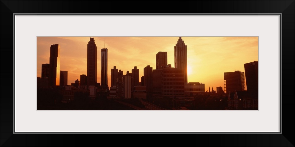 Panoramic photograph displays the sun beginning to set over the skyline of a capital city in the Southeastern United States.
