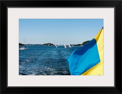 Swedish flag with sailboats in the background, Stockholm Archipelago, Sweden