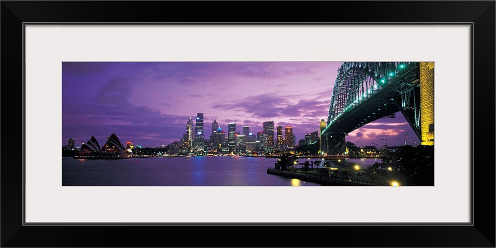 Panoramic photograph of the Sydney skyline with a structure just seen to the right of the picture and purple skies hoverin...