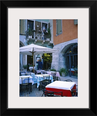Tables and chairs at a sidewalk cafe, Lake Garda, Italy