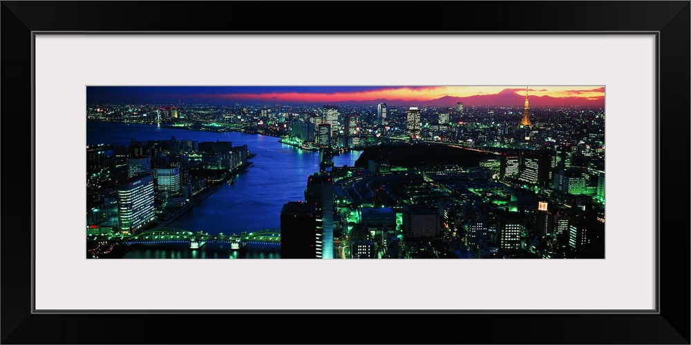 Panoramic photo on canvas of a lit up downtown cityscape with water flowing through it.