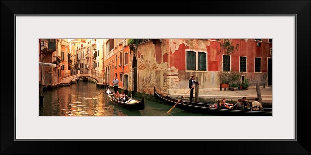 Gondolas paddling through canals lined with historic Venetian buildings.