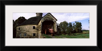 Tractor parked inside of a round barn, Vermont,