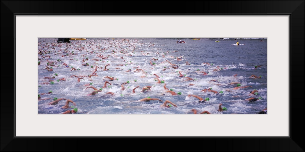 Sports action photograph of hundreds of swimmers racing in the Ironman in Kailua Kona, Hawaii.