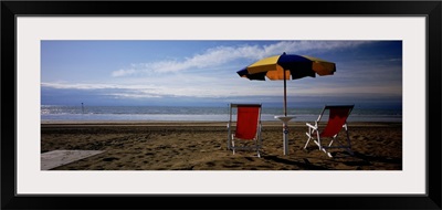 Two empty chairs under a beach umbrella, Lignano Sabbiadoro, Italy
