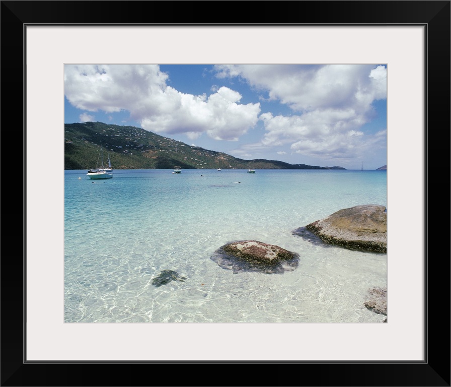 Big photo print of boats floating near the shore of a clear ocean with hills in the background.