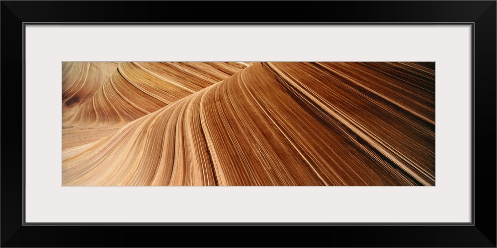 Desert cliff walls streaked with red rock lines flowing through a canyon.