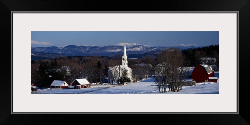 Panoramic photograph displays a number of houses and a church surrounded by bare trees within a small town in the Northeas...