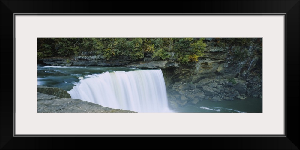 Wall docor of a wide waterfall off of a rocky cliff flowing into a pool of water.