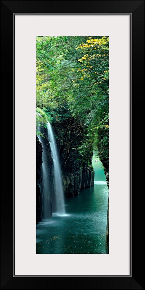 Vertical outdoor shot of a forest, river, and waterfall taken with time-lapsed photography.