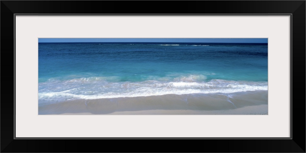 Panoramic picture of waves coming up on the white sandy beach in the Caribbean.