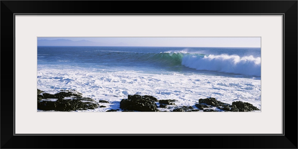 Long image on canvas of big waves crashing onto a rocky shore.