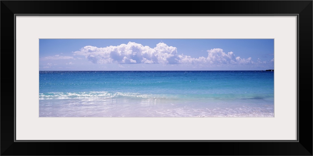 Giant, landscape photograph of a shoreline in Vieques, Puerto Rico.  Small waves of clear blue water rush into the shore.