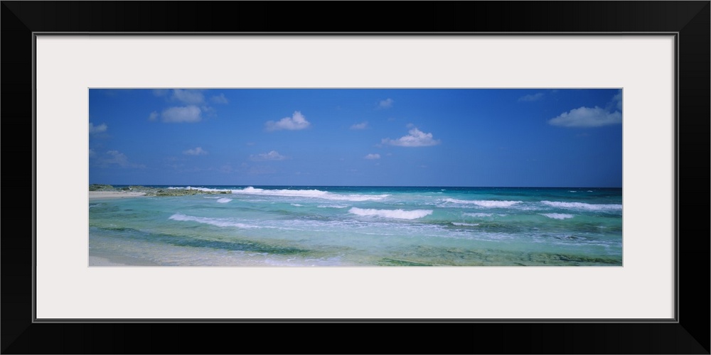 Panoramic image of waves crashing on the beach.