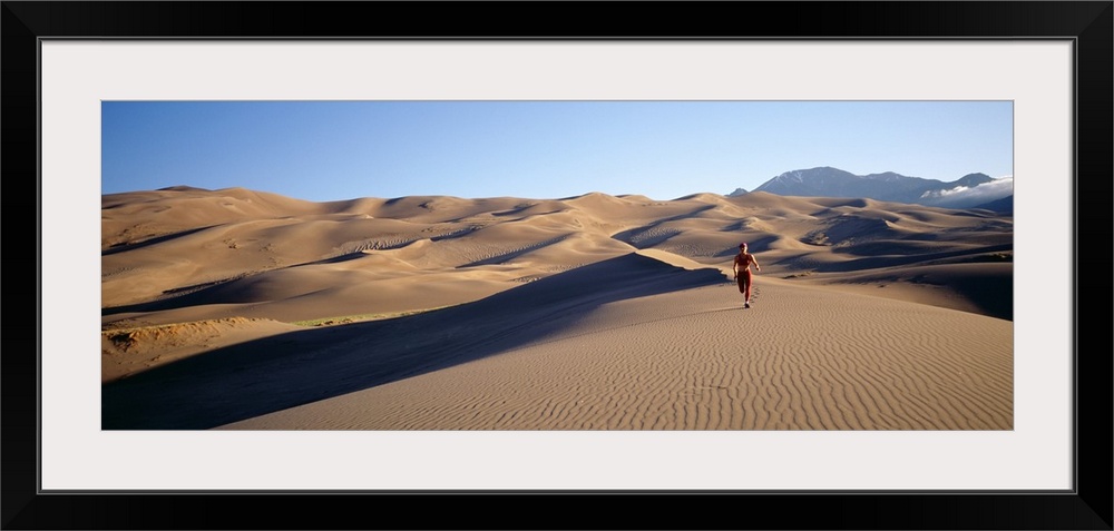 Woman running in the desert, Great Sand Dunes National Monument, Colorado