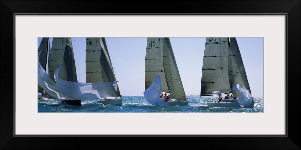 Giant, wide angle photograph of five yachts racing on a sunny day, in the waters of Key West, Florida.