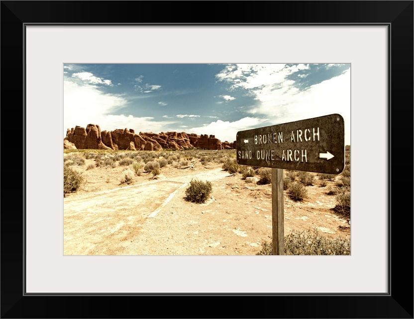 Signpost pointing towards Arches in opposite directions in the desert.