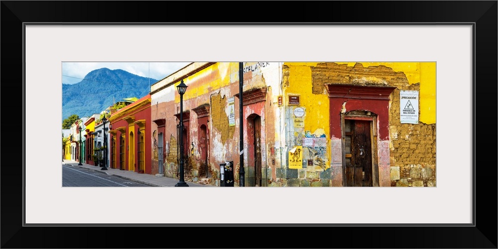 Panoramic photograph of a bright city street in Oaxaca, Mexico, with a view of mountains in the background. From the Viva ...