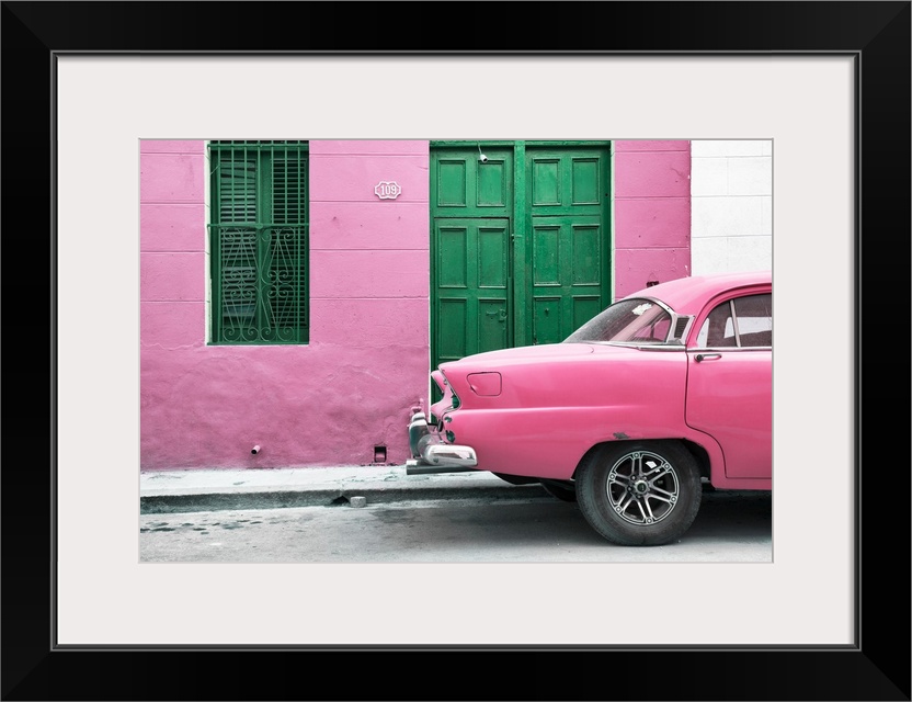 Photograph of the back of a pink vintage car next to a matching facade with a green wooden door and window.