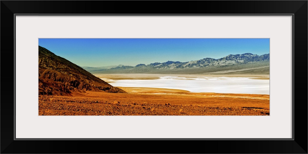 Photo of the Death Valley desert landscape, a flat plain bordered by low mountains.