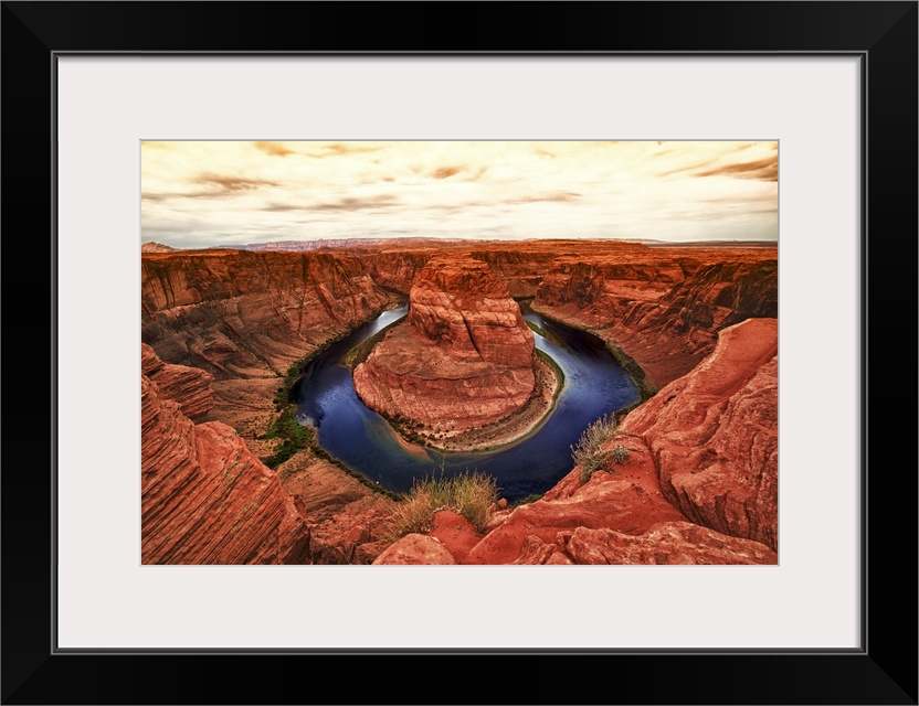 Fine art photograph of Horseshoe Bend in the Arizona landscape under a pale cloudy sky.