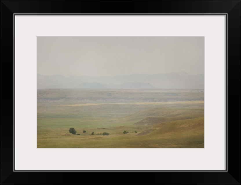 A pictorialist landscape photograph of a western prairie landscape of Montana, USA. Farms up against the buttes form a sce...