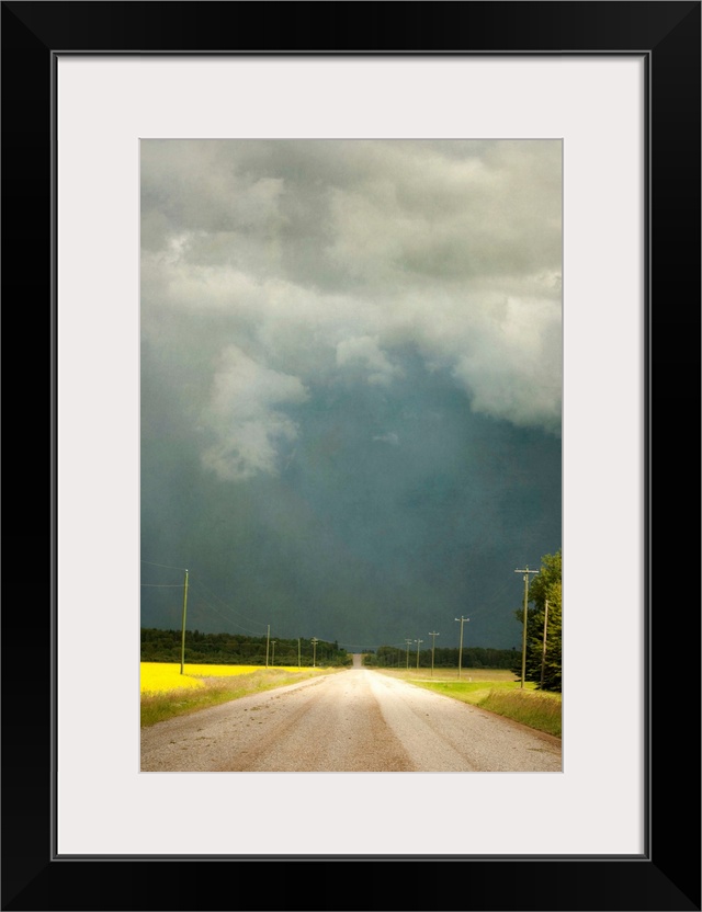 Storm clouds along a lonely stretch of gravel road in the country.