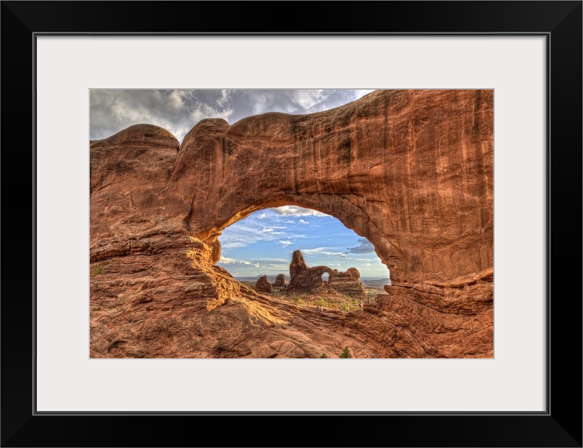 Photograph of a large rock formation seen through a rock arch.