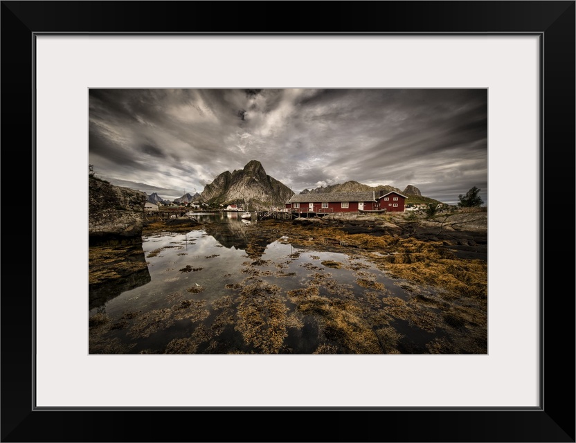 Dynamic photograph of a fishing village under cloudy skies.