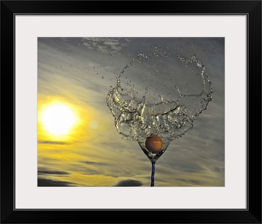 A lemon creating a ring of water as it splashes into a glass.