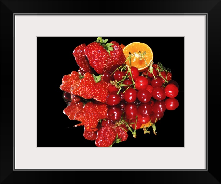 A group of red fruits including strawberries, cherries, and a slice of orange, on a mirror.